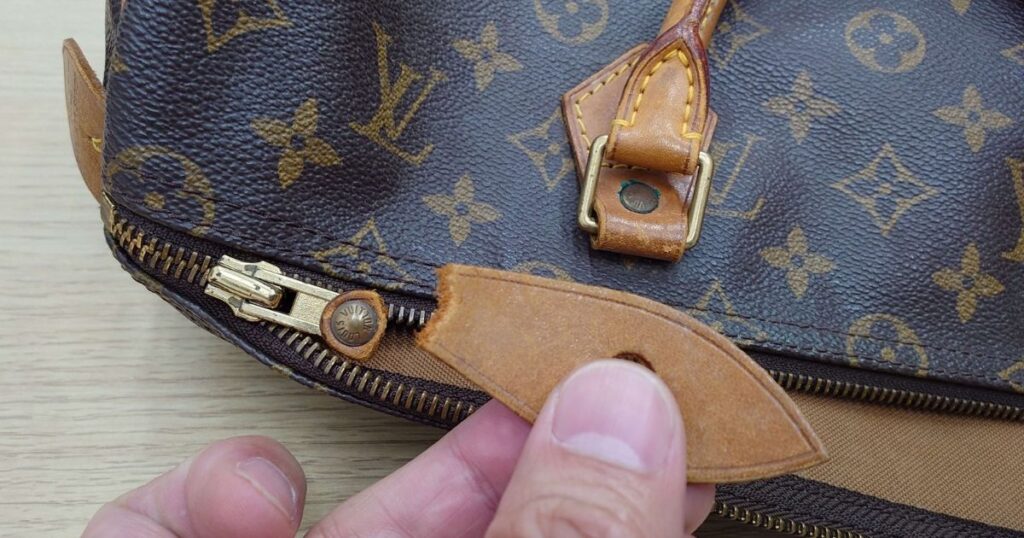 茶色い柄のバッグのファスナーについている革の持ち手がちぎれている